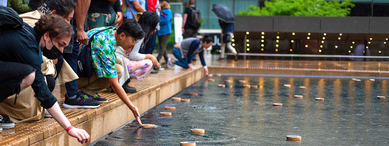 Participants releasing vessels into the reflecting pool at the "Islands in the Sea" installation. / Photo: Ximena Natera