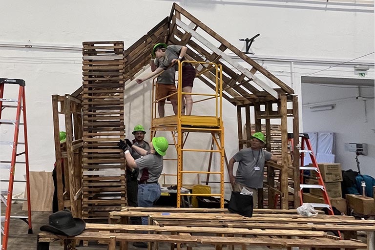 The cabin-like frame is built for the "Our House" installation.