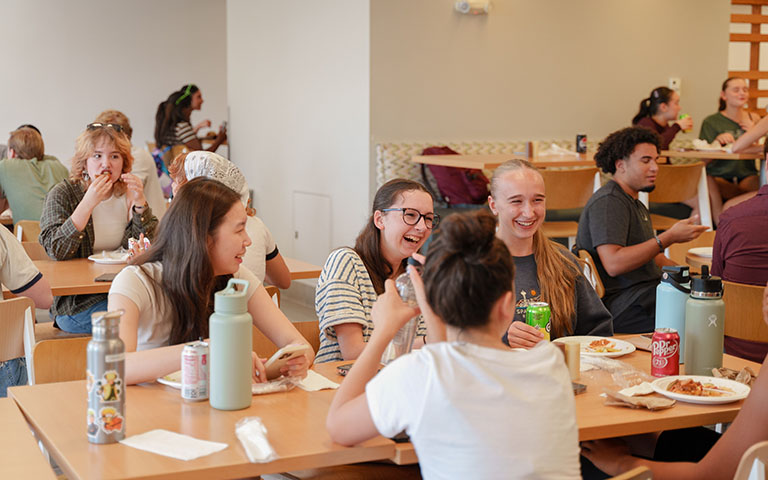 Students eating and laughing in the Dining Hall