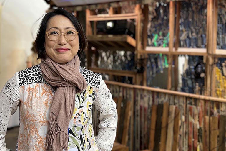 Yoon Bae stands in front of the U.S. exhibit, "Our Home: Unheard Voices of Past and Present."