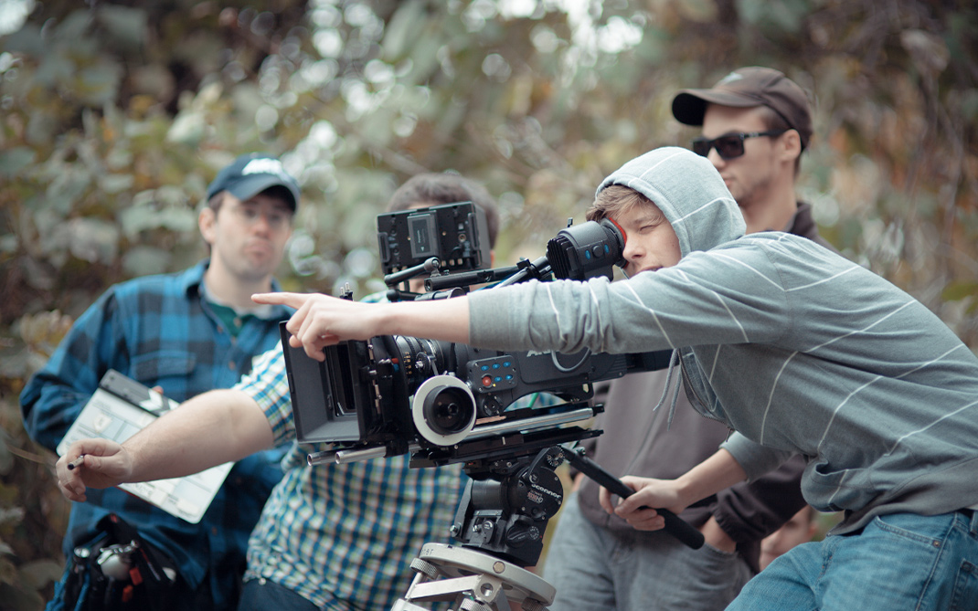 Filmmaking students on set with a camera